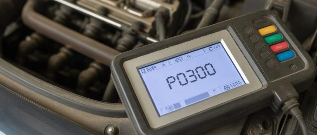 A hand-held OBD-II diagnostic scanner plugged into a car displaying an engine misfire fault code.