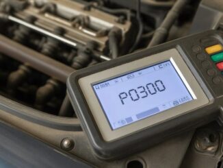 A hand-held OBD-II diagnostic scanner plugged into a car displaying an engine misfire fault code.